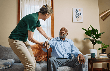 Care giver helps care recipient stand up